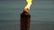 Flame form tiki torch at sunset in slow motion. Vacation and travel concept.