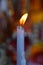 Flame of white melting candle in temple or church