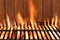 Flaming BBQ Charcoal Cast Iron Grill And Wood Background