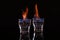 Flaming vodka in shot glasses on black background