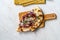 Flammkuchen Pizza Slices / Traditional Tarte Flambee with Creme Fraiche, Cream Cheese, Bacon and Red Onions on Wooden Board