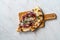 Flammkuchen Pizza Slices / Traditional Tarte Flambee with Creme Fraiche, Cream Cheese, Bacon and Red Onions on Wooden Board