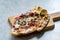 Flammkuchen Pizza Slices / Traditional Tarte Flambee with Creme Fraiche, Cream Cheese, Bacon and Red Onions on Wooden Board