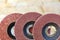 Flap grinding wheels of different grains on wood and metal on a light beige background in unsharp