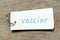 Flash card with hand writing word vaccine on wood background