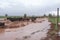 flash flood in farm field, with crops washed away and livestock running for safety