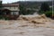 flash flood rushes over bridge and into valley, with houses and roads visible