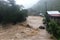 flash flood rushes over bridge and into valley, with houses and roads visible