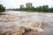 flash flood rushes over riverbank, flooding the surrounding area