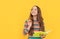 Flash of genius. Happy girl hold copybook pointing pen up. Child genius yellow background