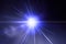 Flash light, lens flares, sun beams effect over dark blue background.