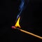 Flashed and burning wooden match on a dark background close-up. Bright fire and smoke from a burning tree