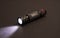 Flashlight with a beam of light agaist a black background
