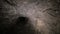 Flashlight illuminates dark passage in cave. Graffiti. Old abandoned mine.