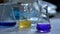 Flasks with yellow and blue liquid in chemistry lab.