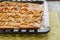 Flat apple pie on a baking sheet