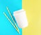 Flat ay top view white paper cup with colored disposable straw on colorful blue and yellow background