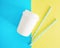 Flat ay top view white paper cup with colored disposable straw on colorful blue and yellow background