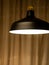 a flat black lamp hangs from the ceiling by a cord.