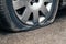 Flat car tire close up, punctured wheel