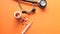 Flat composition of stethoscope , syringe and pills on orange background