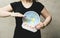 Flat Earther concept. Person who believes that Earth is flat disc. Anonymous woman holding flat Earth model in front of body with