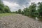 Flat gravel bank on a small river on a cloudy day. Upstream