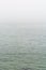 Flat grey sea with wavelets in the fog