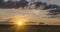 Flat hill meadow timelapse at the summer sunrise time. Wild nature and rural field. Sun rays, trees, green grass