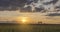 Flat hill meadow timelapse at the summer sunset time. Wild nature and rural field. Sun rays, trees, green grass movement