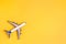 Flat lay airplane on yellow background. Concept of travel