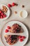 flat lay with arranged cup of milk, sweet pastry, raspberries and almonds on plates