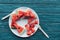 flat lay with arranged watermelon pieces on plate and plastic forks on blue