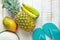 Flat Lay Arrangement Composition Tropical Fruits Pineapple Mango Bananas Women Hat Blue Slippers on White Planked Wood