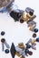 Flat-lay arrangement of variety of double salted licorice spilling from glass candy jar onto white background