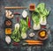 Flat lay with asian cooking ingredients : pak choi , ginger, spices, chili and chopsticks on dark rustic background, top view. Asi