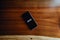 Flat lay of a black phone over a wood background with the word inspire written in it