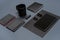 Flat lay of blank black paper sheet, black stationery items and coffee cup on gray desktop. Mock up