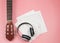 Flat lay of blank music sheet, headphones and acoustic guitar. Musician and leisure concept