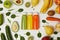 flat lay with bottles with detox smoothies in row with fruits and vegetables on wooden background