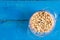 Flat lay bowl with blanched peanuts above blue wooden background
