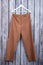 Flat lay brown woman trousers on hanger.