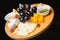 Flat-lay of cheese platter with cheese assortment, figs, honey and nuts over grey concrete background, top view.