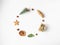 Flat lay Christmas circle frame composition - star cookie, nuts, gift, dry orange slice, Christmas tree and fir branches on white