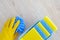 Flat lay cleaning products, copy space. Hand in yellow rubber protective glove with micro fiber cloth. Cleaning service concept.