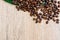 Flat lay, Coffee beans scattered on a light wooden table, top view, closeup grains, place to insert text, copy space