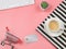 Flat lay of coffee cup on black and white stripes cloth with computer keyboard, shopping cart, credit card and cactus on pink