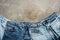 Flat lay collection of fashionable denim blue jeans, border on a dark rustic background. Top view, flat lay, copy space