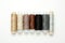 Flat lay colorful cotton thread spools, embroidery yarn, white, brown, gray, black, silver, gold bobbins, mock up, top view.