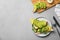 Flat lay composition with avocado toasts on grey table. Space for text